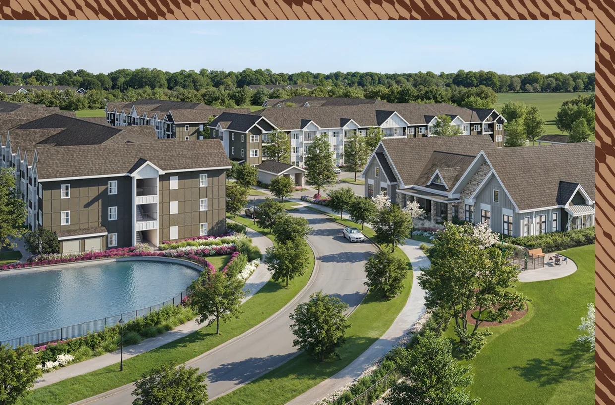 Aerial view of a landscaped apartment community with lake and clubhouse